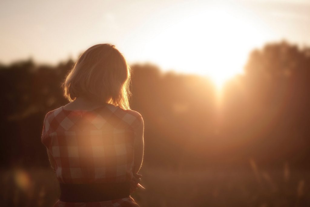 Ragazza di spalle verso il tramonto